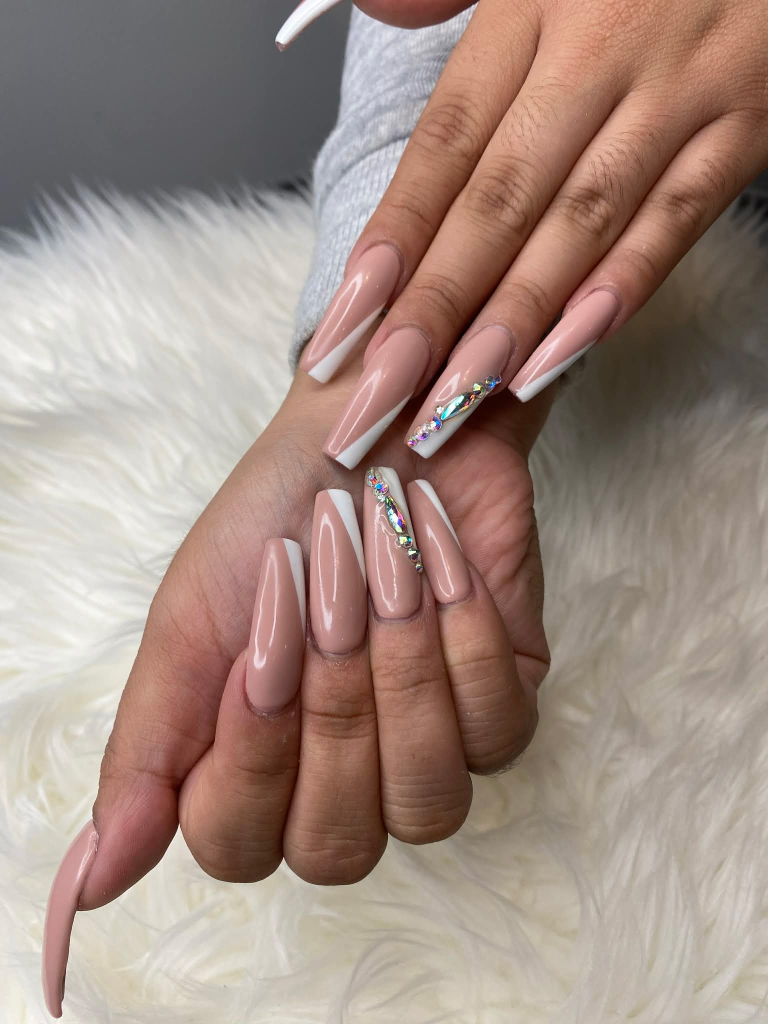 Nude coffin nails with French tips and crystal gem accents by AN Nail Spa