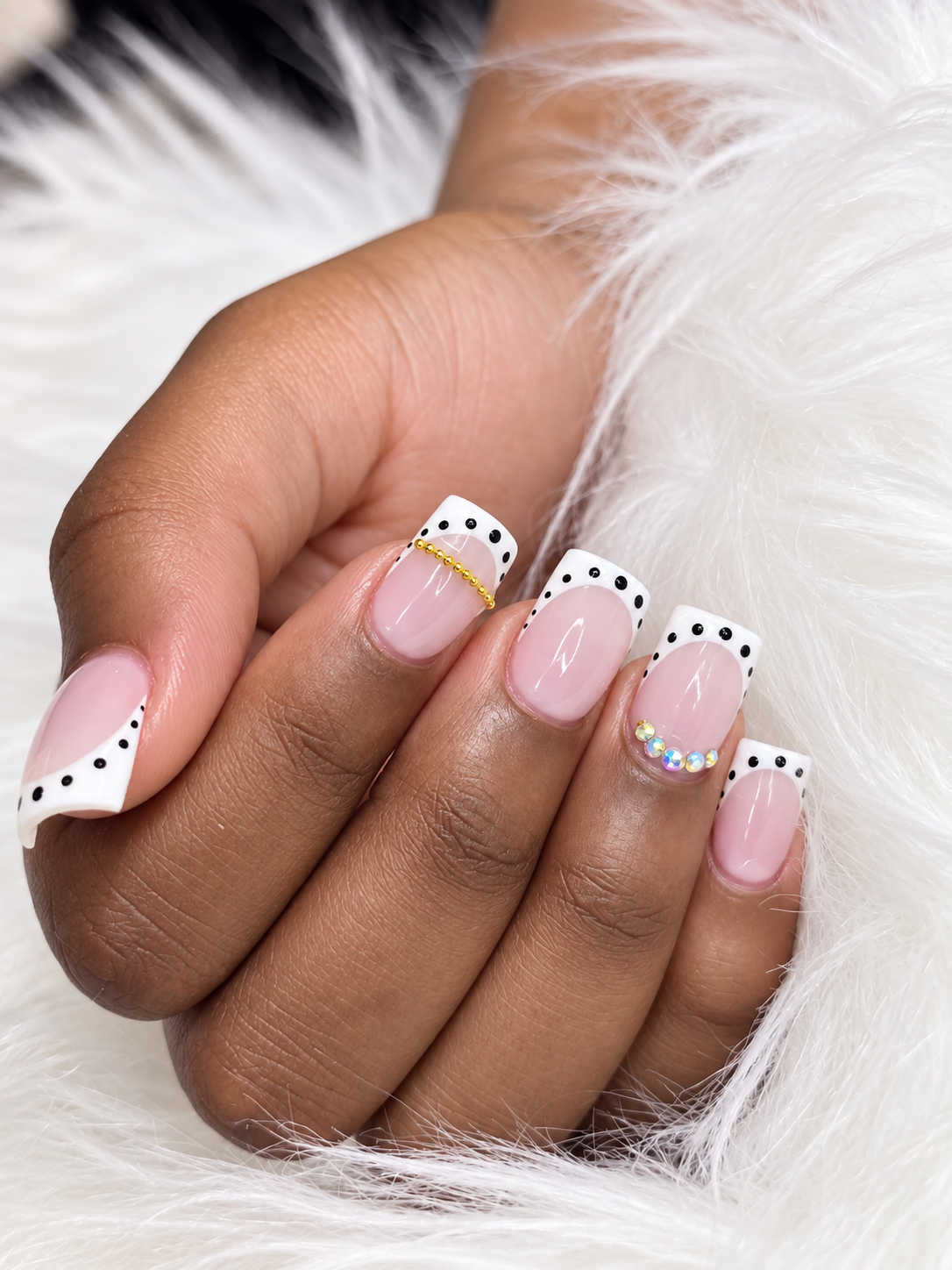 White French tip nails with black polka dots, gold beads and rhinestones by AN Nail Spa