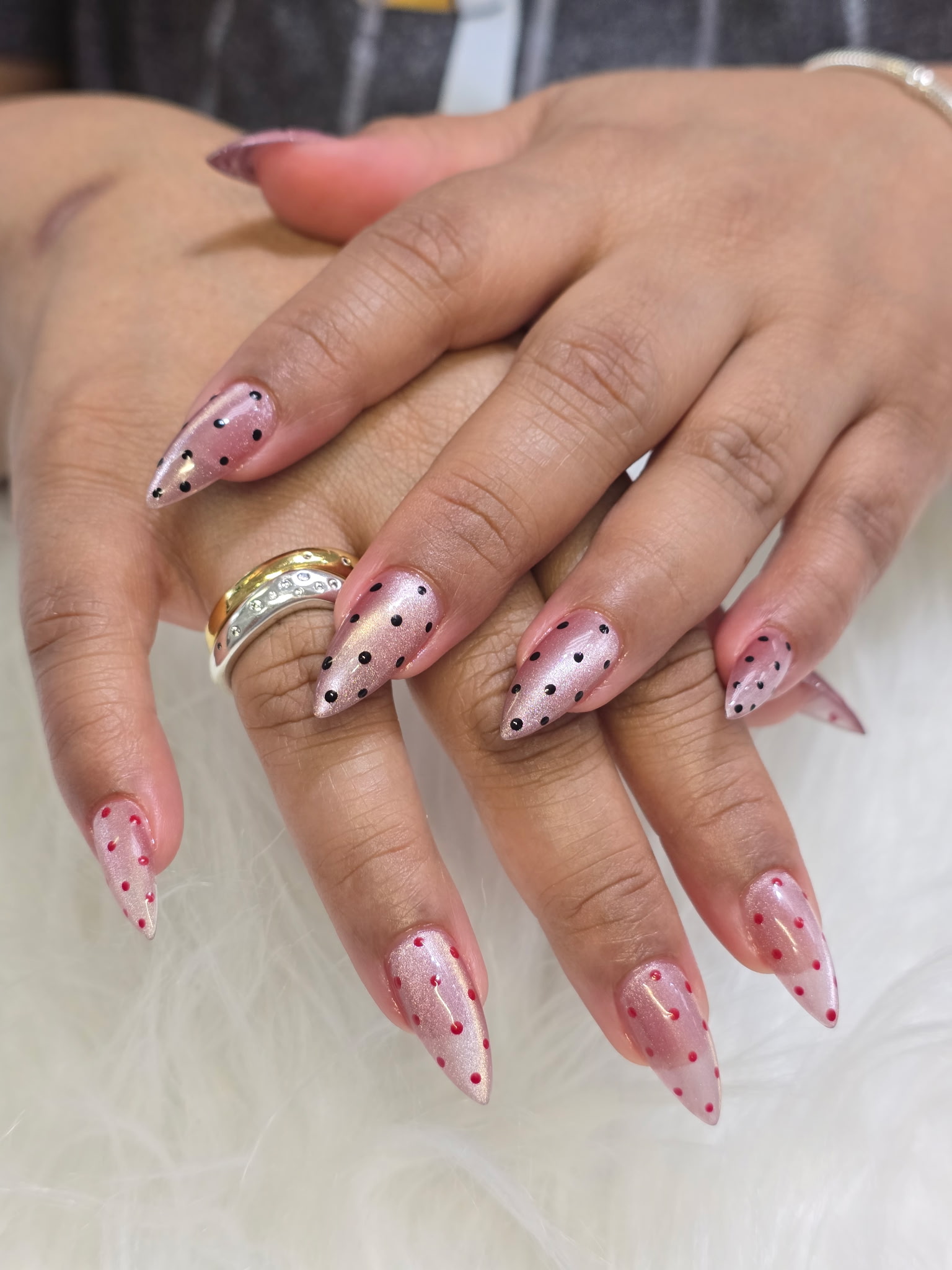 Pink shimmer stiletto nails with black and red polka dot design by AN Nail Spa Toronto